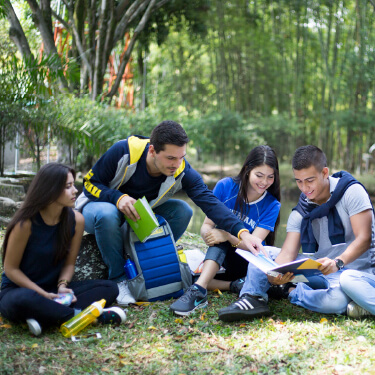 Vida universitaria en la Javeriana Cali Grupo de estudiantes sentados y conversando en el lago de la Universidad Javeriana Cali