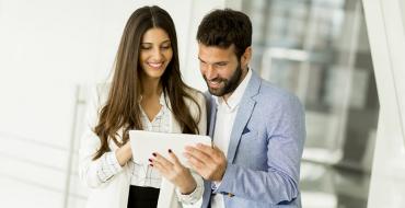 Mujer y hombre de negocios revisando tablet