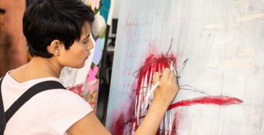 Joven estudiante pintando un lienzo