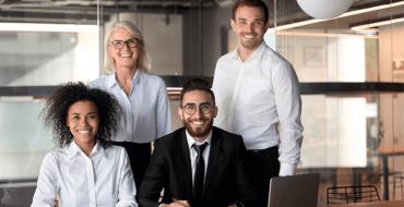 Grupo de personas de distintas edades sonriendo en la oficina