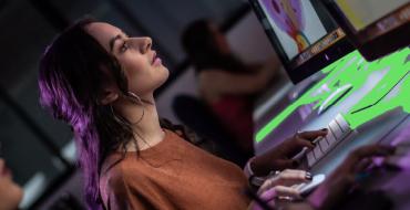 Mujer estudiante de diseño frente a la pantalla del computador diagramando