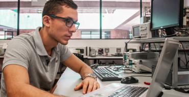 Joven estudiante en labotario revisando datos frente el computador