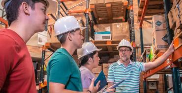 Profesor y estudiantes visitan bodega en clase práctica de Ingeniería Industrial