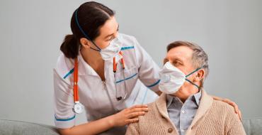 Doctora con paciente adulto mayor y mascarillas de protección