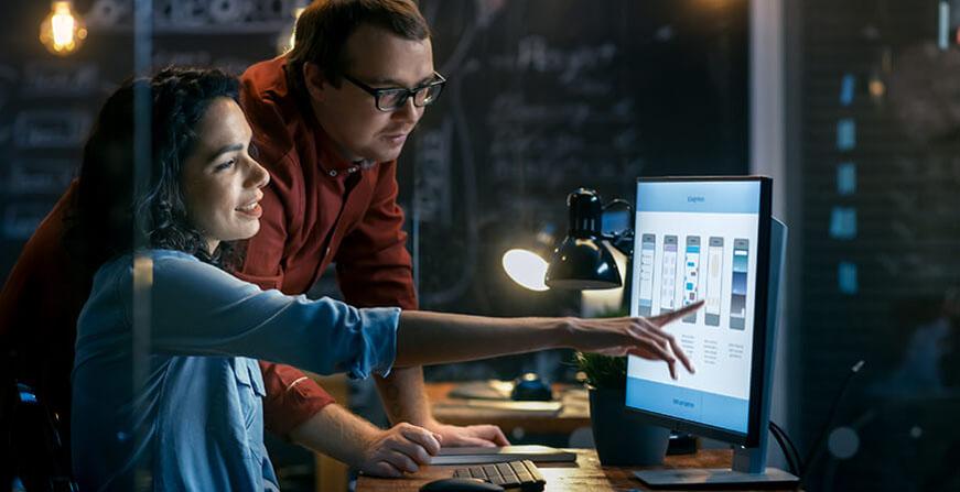 Especialización en Ingeniería de Software Mujer y hombre mirando la estructura de una aplicación en la pantalla de un computador