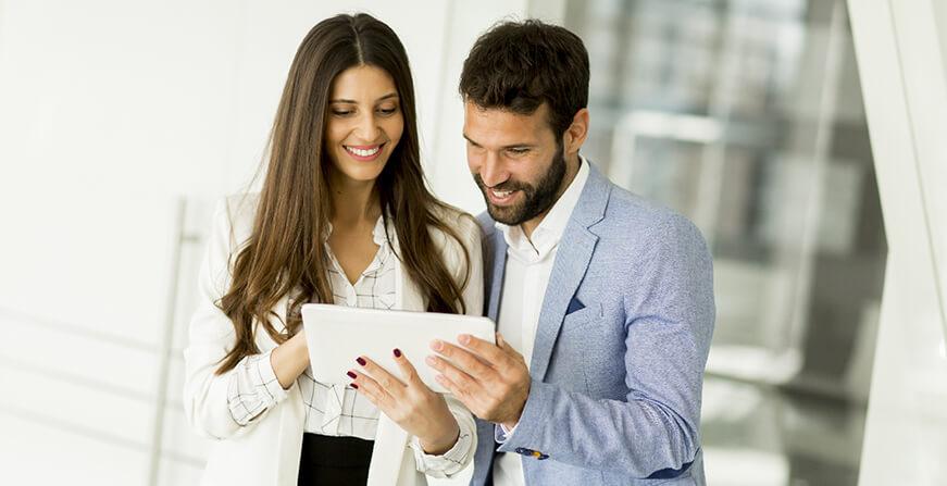 Maestría en Administración de Empresas (MBA) - Cali Mujer y hombre de negocios revisando tablet