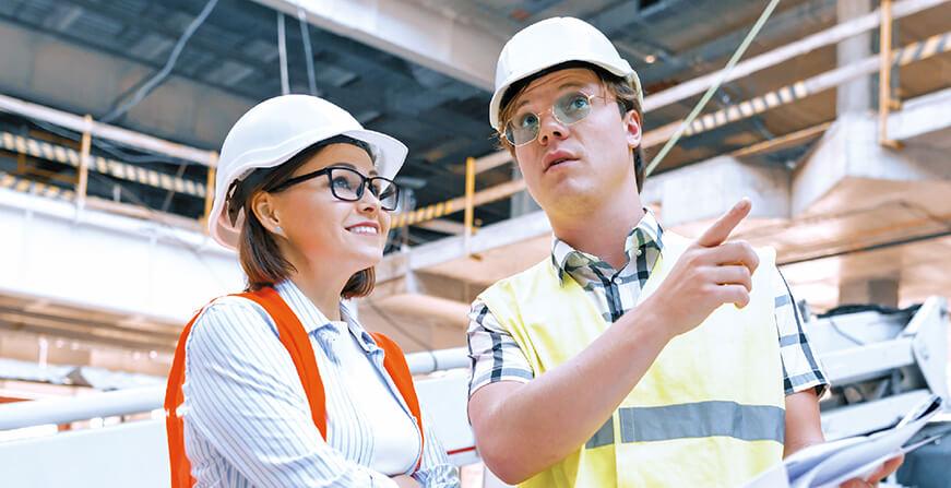 Maestría en Ingeniería Civil Mujer y hombre con casco de construcción blanco conversando