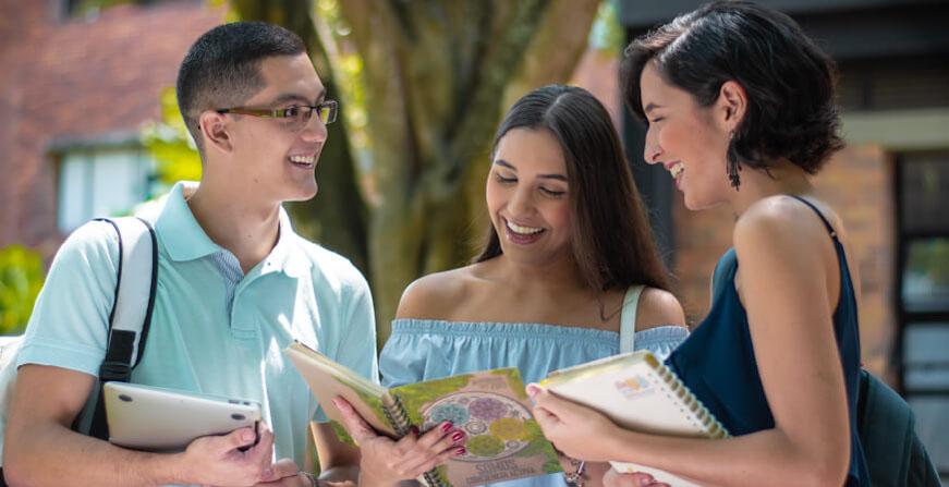 Estudiantes de Ciencia Política Grupo de jóvenes conversando y revisando apuntes en sus cuadernos