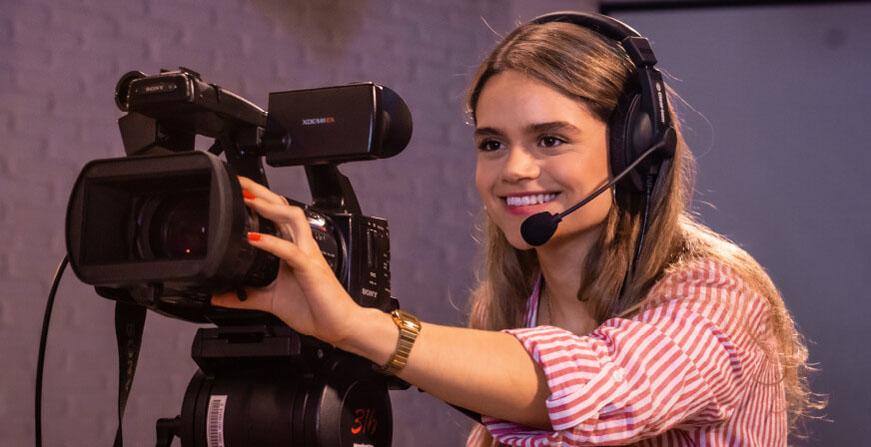 Estudiante de Comunicación Joven estudiante con cámara de video y micrófono