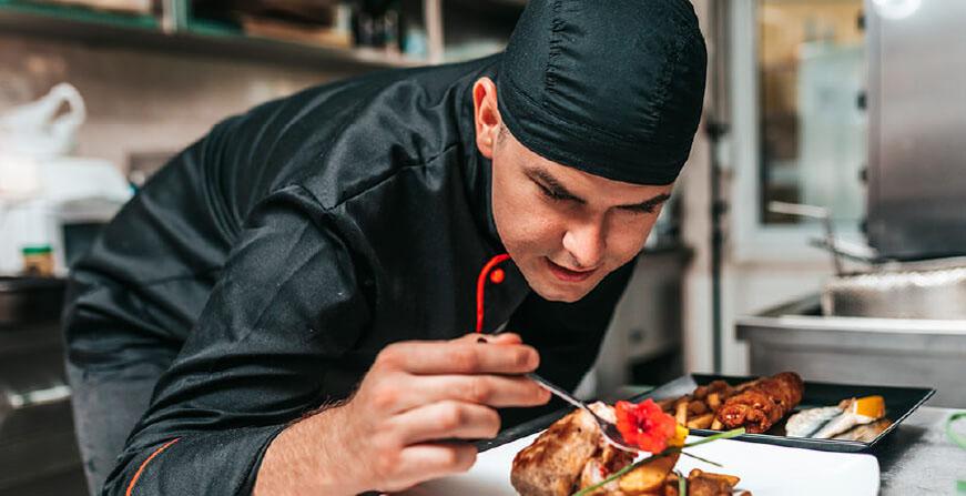 Gastronomía de la Javeriana Cali Joven estudiante decorando el plato con flor roja